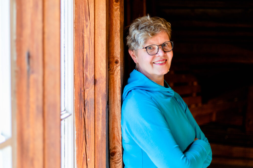 Marjo Kalavainen nojaa sisällä ikkunanpieleen.