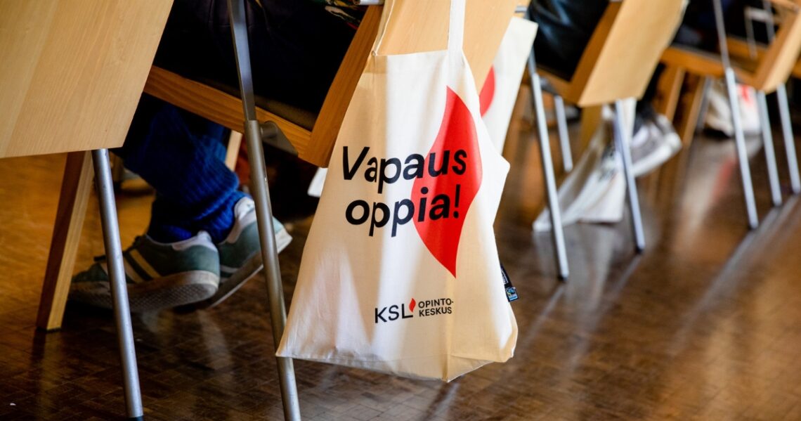 Tuolin selkämykselle on ripustettu kangaskassi, jossa lukee Vapaus oppia! ja KSL-opintokeskuksen liekkilogo.